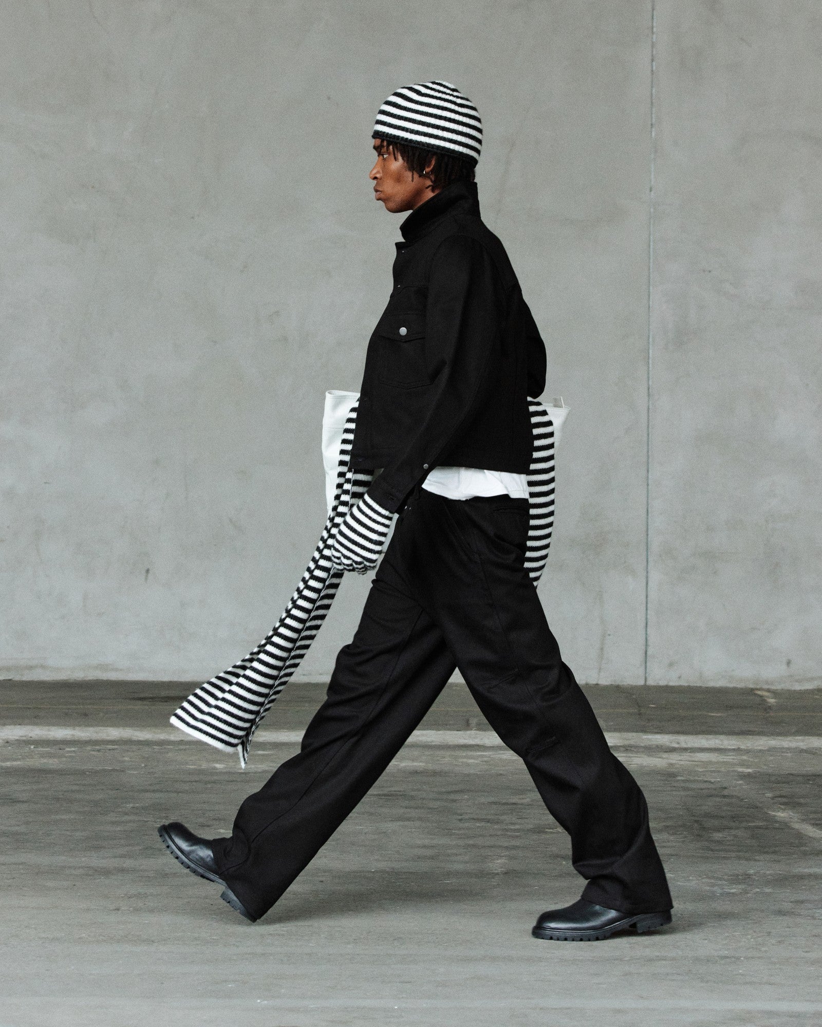 FW26 runway — striped knit under black overshirt